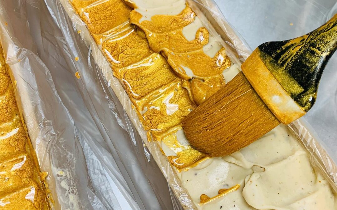 An organic bar of soap being painted with gold.